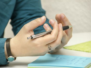 a person sitting at a table using a cell phone